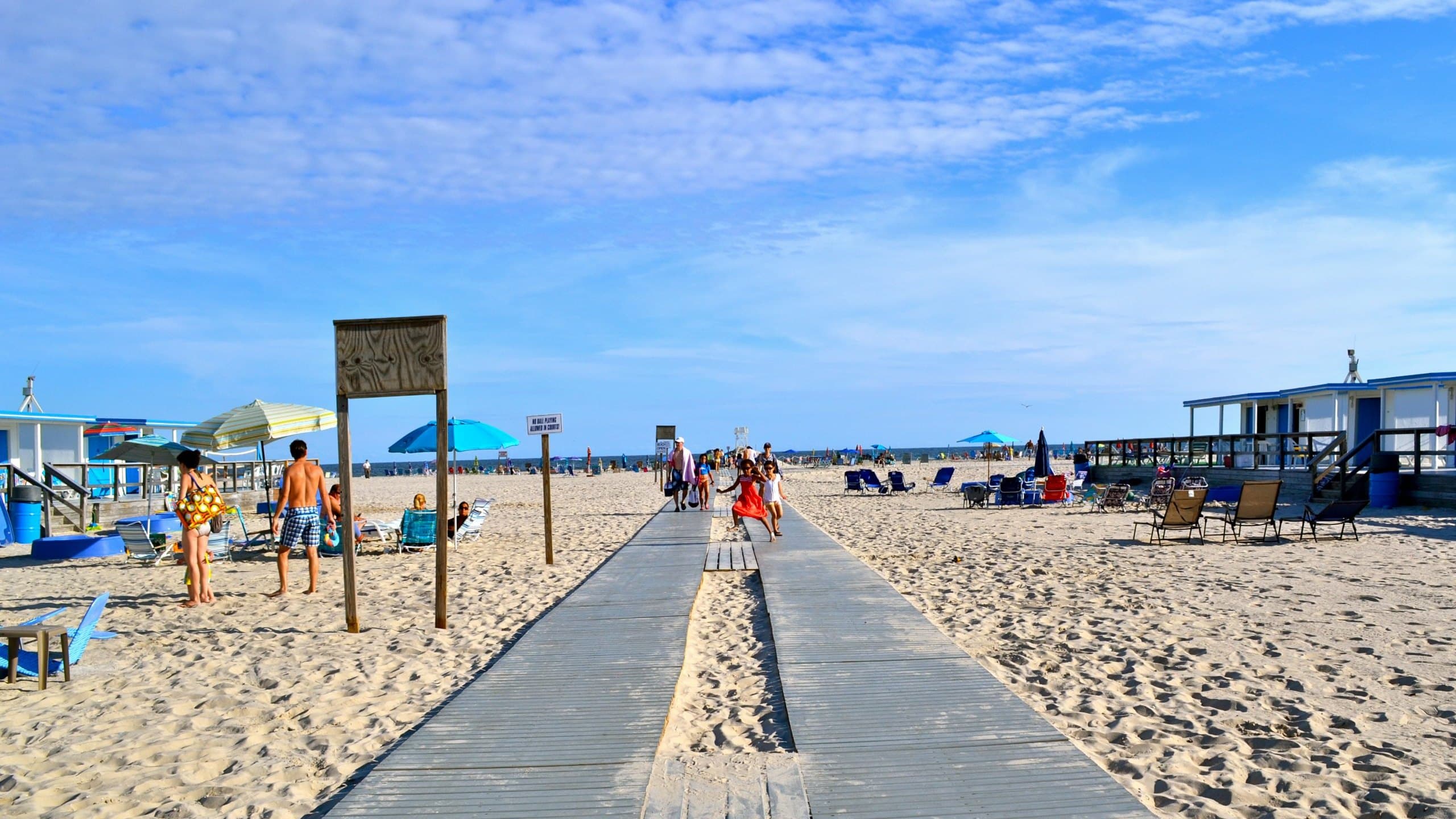 The boardwalk at The Sands running down the white sand to the Atlantic, cabana rows on both sides