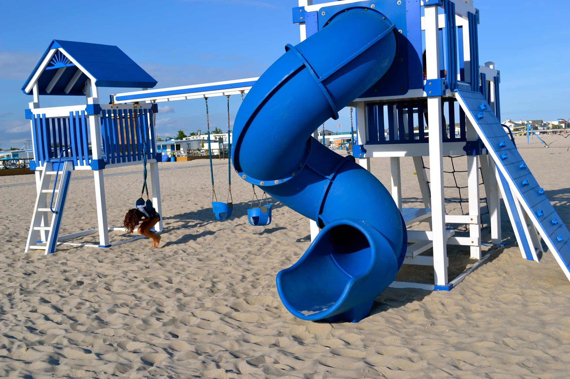 The playground on the sand at The Sands, a blue and white play structure with a spiral tube slide