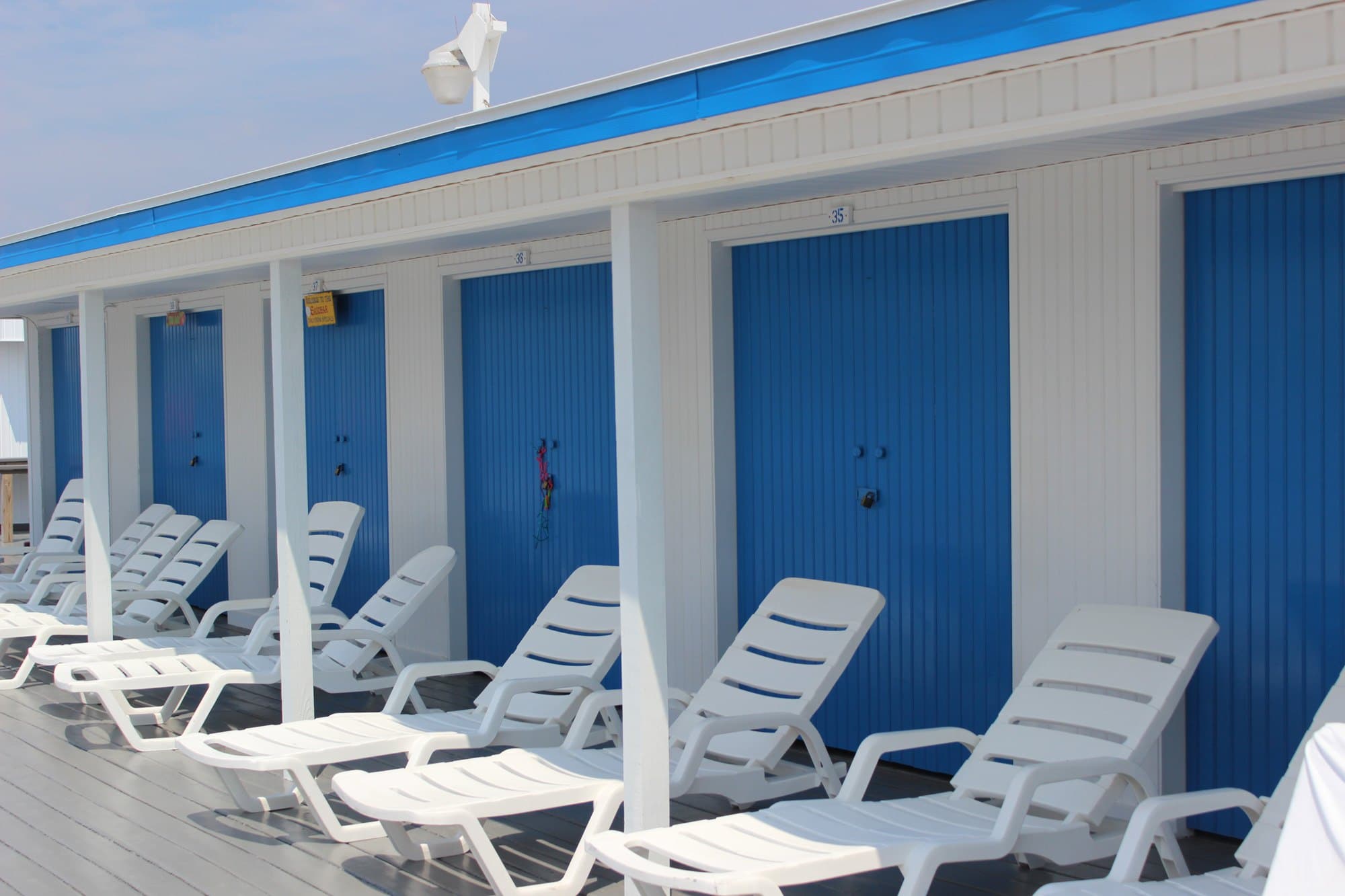Numbered shower cabin doors at The Sands, 35 through 38, along the deck with loungers outside