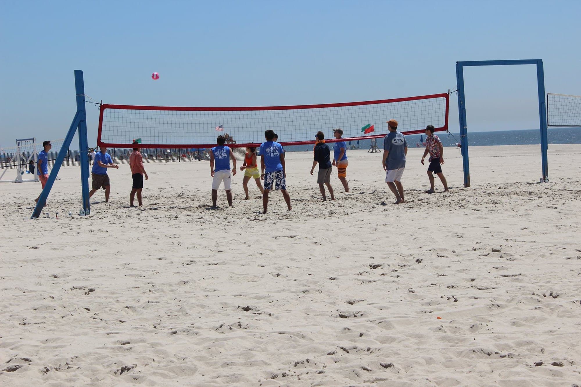 A beach volleyball game in progress on the white sand at The Sands